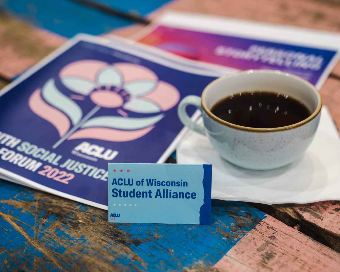 Display of an ACLU of Wisconsin Student Alliance card next to a cup of coffee